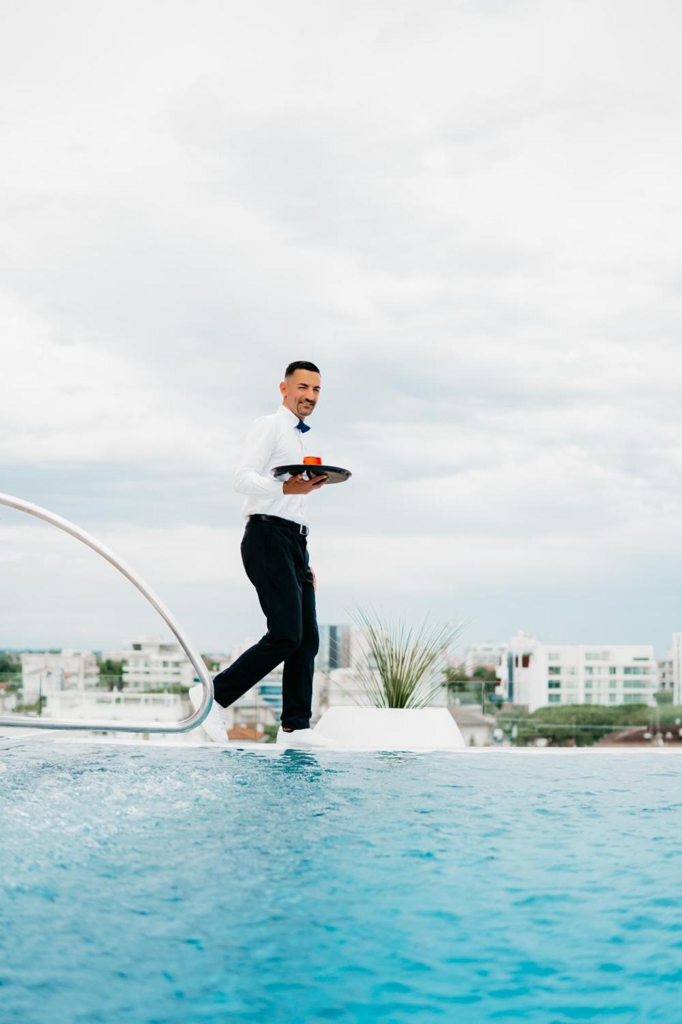 J44 Lifestyle Hotel Lido di Jesolo Esterno foto A waiter balancing on a tightrope